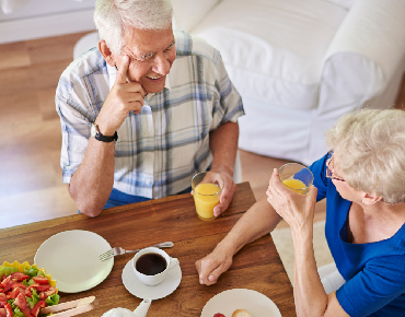 Family member spending quality time with their loved one while professional caregivers manage ventilator care and daily needs.