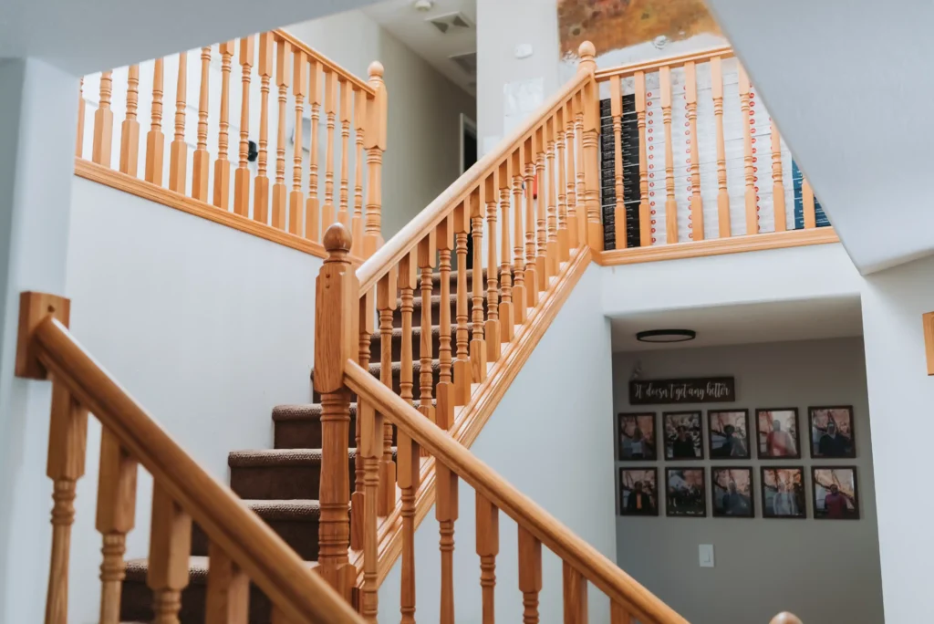 Wooden staircase with railings inside a bright modern house.