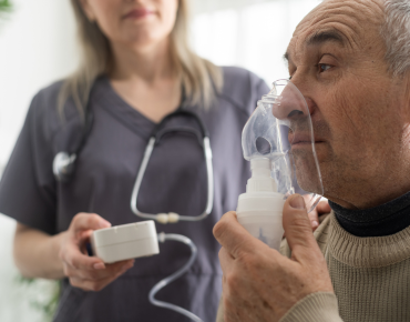 Healthcare professional coordinating with trained nurses and caregivers to provide advanced ventilator support in a homelike setting.