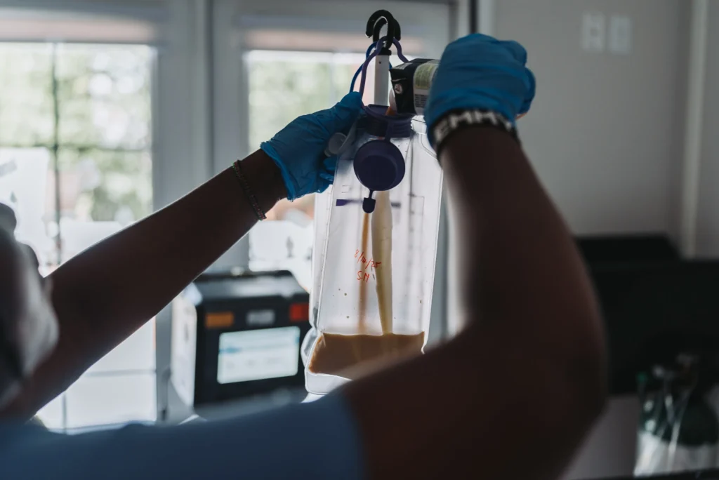 Nurse preparing an IV drip for a patient in a healthcare setting.